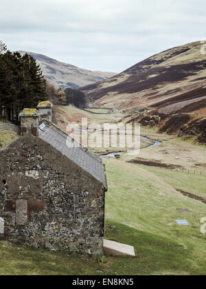 Ein Blick auf die Pentland Hills und den Fluss hinunter aus dem Loganlea Reservoir mit einem kleinen Steinhaus Stockfoto