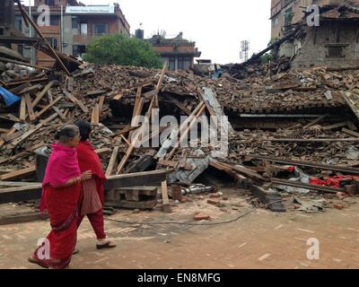 Kathmandu, Nepal. 29. April 2015. Nepalesische Frauen gehen vorbei an einem Gebäude durch das massive Erdbeben das Kathmandu-Tal 29. April 2015 in Bhaktapur, Nepal abgeflacht. Das verheerende Erdbeben mehr als 5.000 Menschen getötet und zerstörte große Teile der historischen Altstadt. Stockfoto