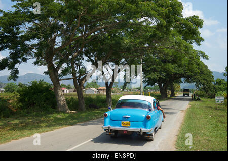 VINALES, Kuba - 20. Mai 2011: Amerikanische Oldtimer rollt eine ruhige ländliche Landstraße. Stockfoto