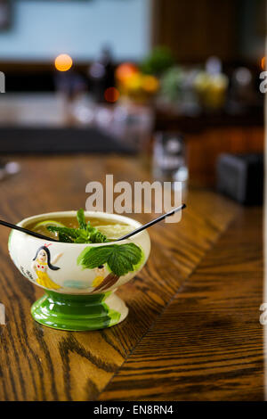 Ein tropischen cocktail in der Tiki-Tasse mit zwei Strohhalmen setzt sich auf eine Bar. Stockfoto