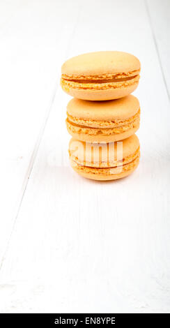 Satz von Macarons isoliert auf weißem Holztisch Stockfoto