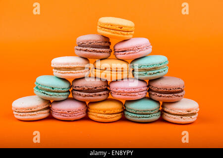 Satz von Macarons auf orangem Hintergrund isoliert Stockfoto