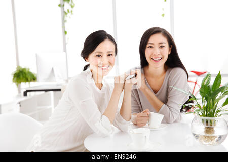 Zwei junge Frauen in den Büroklatsch Stockfoto
