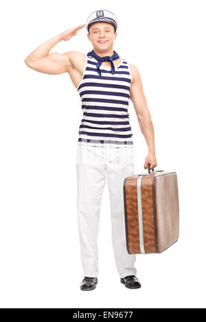 Voller Länge Porträt eines jungen männlichen Matrosen salutieren in Richtung der Kamera und halten eine Aktentasche isoliert auf weißem Hintergrund Stockfoto
