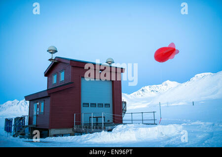 Forscher bereiten einen Mini Zeppelin hinter der atmosphärischen Observatorium in der Kings Bay-Forschungsstation in Ny-Alesund auf Spitzbergen, Norwegen, 9. April 2015. Der Ballon trägt Messsonden der Forschungsbasis AWIPEV in verschiedenen Höhen und sammelt Messdaten wie Temperatur, Luftfeuchtigkeit und Luftdruck. Foto: Jens Büttner/dpa Stockfoto