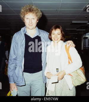 Schauspieler Colin Baker, der Doctor Who in der BBC-Science-Fiction-Programm spielt, fotografiert mit seiner Assistentin Nicola Bryant, Perpugilliam "Peri" Brown am Flughafen Heathrow, spielt vor der Abreise nach einer Convention in Miami. 2. Februar 1984. Stockfoto