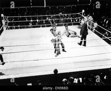 Boxen bei Olympia, Kensington, London, Vereinigtes Königreich. Joe Beckett v. Frank Goddard. Beckett Schläge nach unten Goddardand ist zurückhaltend, durch den Schiedsrichter. 17. Juni 1919. Stockfoto