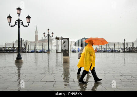 Menschen mit Regenschirme und Regenmäntel an einem regnerischen Tag entlang der Riva Degli Schiavoni aus Ducale, Venedig, Veneto, Italien Stockfoto