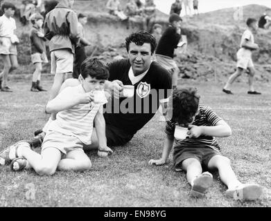 Bobby Smith von Tottenham Hotspur trinken eine Tasse Tee mit zwei jungen während einer Trainingseinheit in Cheshunt. 22. August 1963. Stockfoto