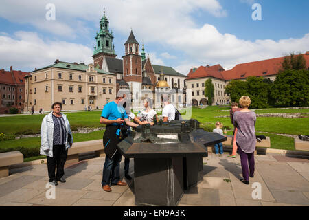 Touristen besuchen das Modell der Burg mit dem echten Königsschloss Wawel hinter auf Wawel in Krakau, Polen, im September Stockfoto