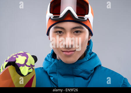 Porträt eines jungen Mannes, ein Snowboard, Blick in die Kamera halten Stockfoto