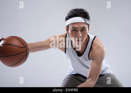 Junger Mann, Basketball spielen Stockfoto