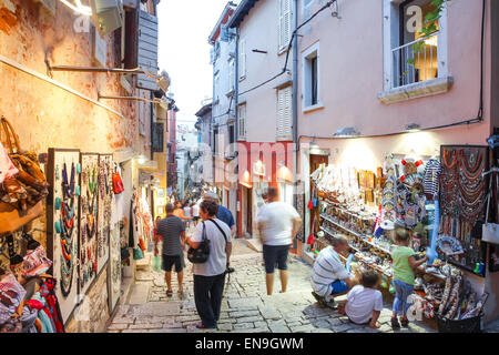 Menschen zu Fuß auf der Straße neben dem Souvenirgeschäfte und Sehenswürdigkeiten Souvenirs auf den Wänden der Gebäude angezeigt. Stockfoto