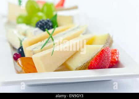 Käse mit Beeren auf einem weißen Teller Stockfoto