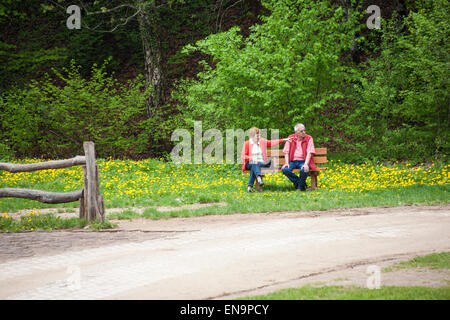 Älteres paar sitzen auf Bank im Bereich der Butterblumen am Nationalpark Plitvicer Seen, ein UNESCO-Weltkulturerbe in Kroatien Stockfoto