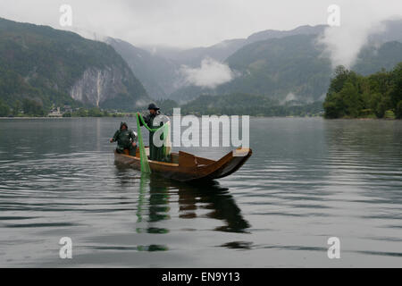 Fischer auf eine Plaette Boot an einem regnerischen Morgen am Grundlsee, Steiermark, Österreich Stockfoto