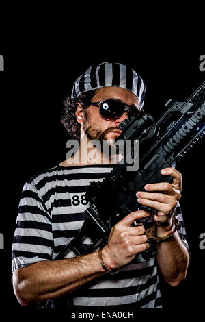 Freiheit. Gefängnis-Aufruhr-Konzept. Mann mit einem Maschinengewehr, Gefangener Stockfoto