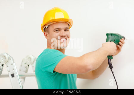 Mann mit Bohrmaschine Loch in der Wand machen Stockfoto