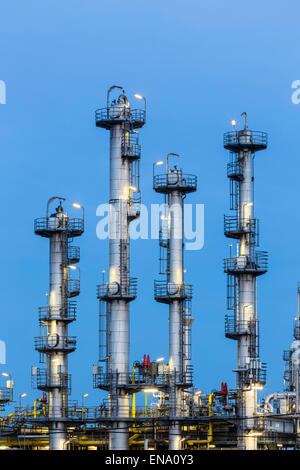 Detail der vier Türme der Destillation in einer Chemiefabrik und Raffinerie mit blauen Nachthimmel. Stockfoto