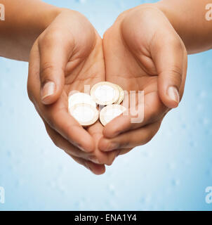 Womans schalenförmige Hände mit Euro-Münzen Stockfoto