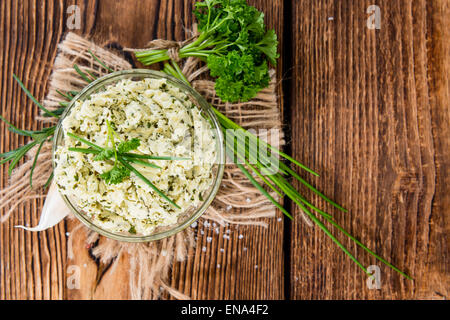 Portion Kräuterbutter (mit Schnittlauch, Basilikum, Oregano, Petersilie und Rosmarin) auf rustikalen hölzernen Hintergrund Stockfoto