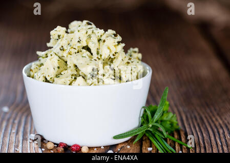 Portion Kräuterbutter (mit Schnittlauch, Basilikum, Oregano, Petersilie und Rosmarin) auf rustikalen hölzernen Hintergrund Stockfoto