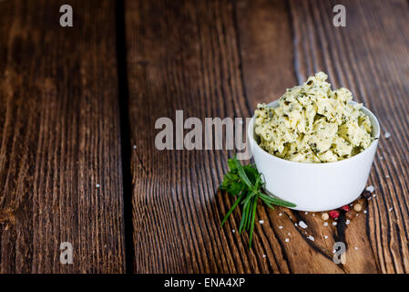 Portion Kräuterbutter (mit Schnittlauch, Basilikum, Oregano, Petersilie und Rosmarin) auf rustikalen hölzernen Hintergrund Stockfoto