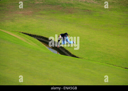 Golfer Abrufen von Kugel aus dem Stream. Stockfoto