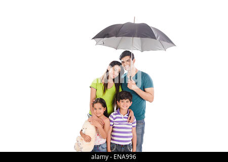 indische Eltern und Kinder Raining Umbrella Schutz Stockfoto