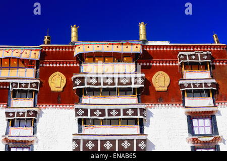 Vergoldete Rondelle und Dhvajas-Sieg Banner auf Dachterrasse Wit Überdachungen auf dem Balkon. Potala-Palast mit Potrang Karpo + Marpo. Lhasa. Stockfoto