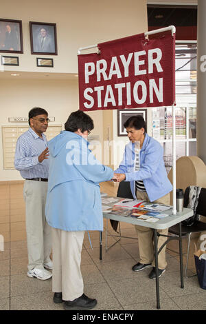 Warren, Michigan USA - christliche Aktivisten beten mit einer Frau an ihrem Gebet Posten in der Lobby des Rathauses. Ein paar Schritte entfernt, Personal Atheisten "Grund-Station." Ursprünglich, erlaubt die Stadt nur die Gebet-Station. Es dauerte ein Bundesgericht um die Atheisten ihre Tabelle einrichten lassen. Bildnachweis: Jim West/Alamy Live-Nachrichten Stockfoto