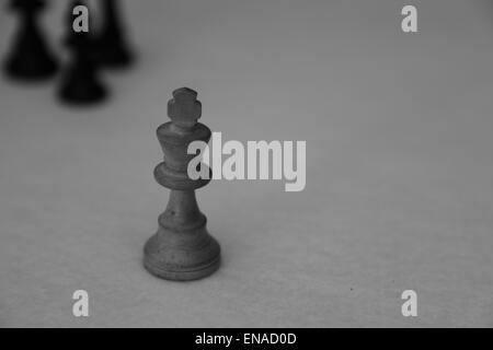 Der weiße König aus einem Schach gesetzt wird von drei schwarzen Schachfiguren bedroht Stockfoto