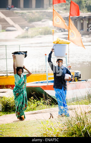 Zwei Frauen, die Wäsche von der Überquerung des Flusses in Hampi. Stockfoto