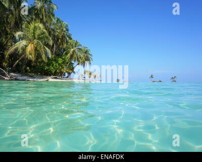 Meeresoberfläche mit türkisfarbenem Wasser und tropische Insel Ufer mit Kokospalmen, Karibik, Panama Stockfoto
