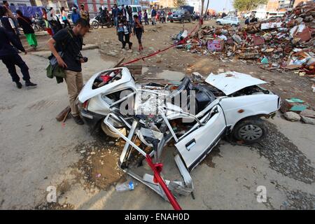 Kathmandu, Nepal. 30. April 2015. Ein Tourist schaut auf eine beschädigte Taxi am Gongabu in Kathmandu, Nepal, 30. April 2015. Die Zahl der Todesopfer durch ein starkes Erdbeben in Nepal kletterte auf 5.844, sagte das Land Ministerium des Innern in seiner neuesten Update am Donnerstag. Bildnachweis: Sunil Sharma/Xinhua/Alamy Live-Nachrichten Stockfoto