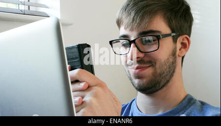 Mann mit Handy während der Sitzung auf Bett Stockfoto, Bild: 98820059