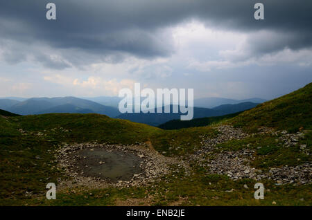 Schlammige Pfütze in den Bergen mit Blick auf den Bereich Stockfoto