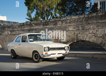 Ford MKI Escort in Malta in weiß neben einigen Bögen Stockfoto