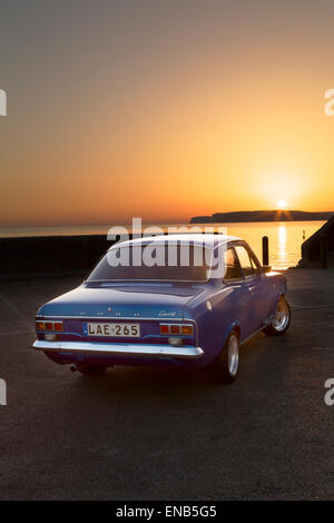 Ford MKI Escort in Malta am Cirkewwa Hafen bei Sonnenuntergang, einer der beliebtesten Tauchziele Maltas. Stockfoto