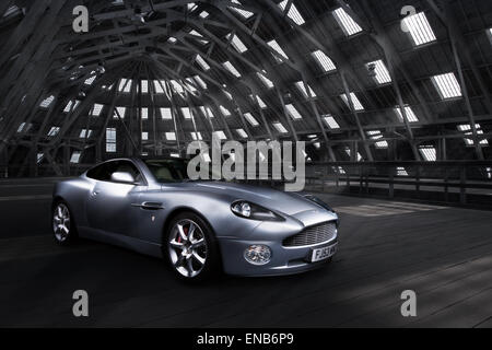 Aston Martin Vanquish in einem alten Industriegebäude mit Fenstern und Ströme von Licht über Fahrzeug fallen. Stockfoto