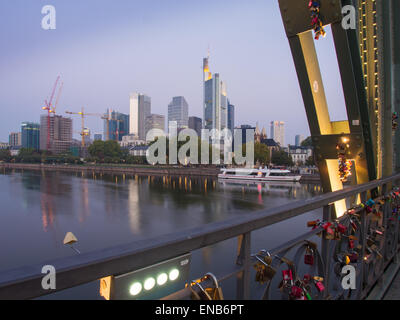Die Skyline von Frankfurt am Main, bei Sonnenaufgang, gesehen von der Eiserner Steg Brücke, mit einem Passagierschiff auf dem Main Stockfoto