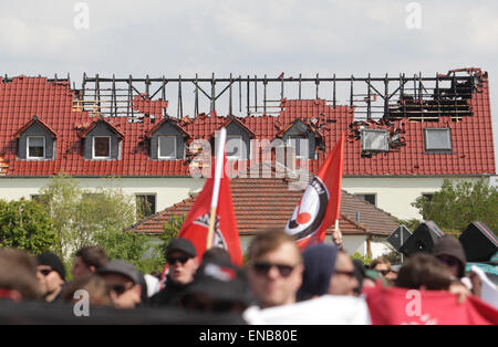 Troeglitz, Deutschland. 1. Mai 2015. Teilnehmer an einer Demonstration gehen vorbei an einem geplanten Flüchtlingsheim, die bei einem Brandanschlag in Troeglitz, Deutschland, 1. Mai 2015 zerstört wurde. Hunderte von Menschen protestieren gegen Fremdenhass. Ein Kollektiv von antifaschistischen Gruppen zur Demonstration aufgerufen. Foto: SEBASTIAN WILLNOW/Dpa/Alamy Live News Stockfoto