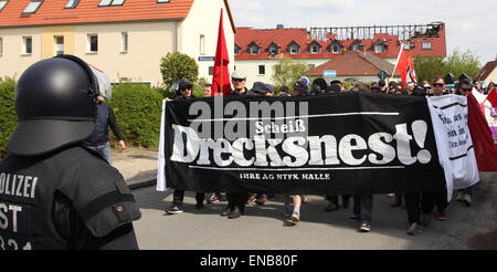 Troeglitz, Deutschland. 1. Mai 2015. Teilnehmer an einer Demonstration tragen einen Banner geschrieben mit "mieses Dump" gehen vorbei an einer geplanten Flüchtlings-Haus, das bei einem Brandanschlag in Troeglitz, Deutschland, 1. Mai 2015 zerstört wurde. Hunderte von Menschen protestieren gegen Fremdenhass. Ein Kollektiv von antifaschistischen Gruppen zur Demonstration aufgerufen. Foto: SEBASTIAN WILLNOW/Dpa/Alamy Live News Stockfoto