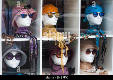 Schaufensterpuppe Köpfe tragen Hüte und Brille auf dem Display im Schaufenster des Geschäfts in Swanage, Dorset UK im Mai Stockfoto