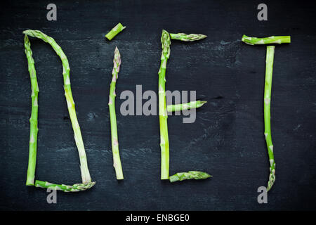 Wort Diät Spargel Gemüse auf schwarzer Holzplatte, Ansicht von oben gemacht. Gesunde Ernährung-Konzept Stockfoto