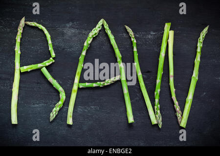 Wort rohen Spargel Gemüse auf schwarzer Holzplatte, Ansicht von oben gemacht.  Gesunde Ernährung-Konzept. Stockfoto