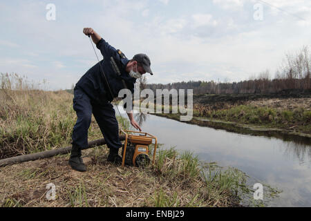 Tschernobyl, Ukraine. 1. Mai 2015. Ukrainische Feuerwehrleute Rest und Pumpe Wasser aus einem kleinen Fluss nach der Brandbekämpfung in der Nähe des Dorfes Lubjanka, ca. 25 km von Chernobyl Nuclear Power plant, Ukraine, 1. Mai 2015. Ein Lauffeuer tobte nahe, dass das Kernkraftwerk von Tschernobyl ukrainische Behörden sagte am 29 April unter Kontrolle gebracht wurde. Feuerwehrleute die Flammen an der weiteren Ausbreitung gestoppt haben, sagte der ukrainischen Notdienst Situationen, die des Landes Feuerwehr betreut, in Kiew. Bildnachweis: ZUMA Press, Inc./Alamy Live-Nachrichten Stockfoto