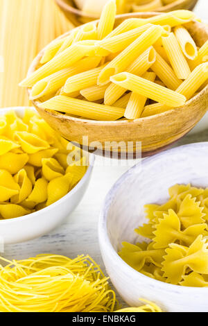 Vielzahl von gelben trockene Teigwaren in kleiner Runde Schalen. Stockfoto