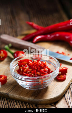Rote Chilis (geschnitten) auf Vintage Holz-Hintergrund Stockfoto