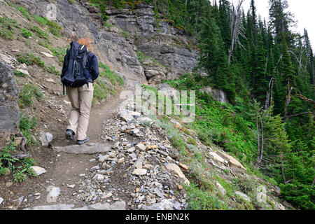 weibliche Wanderer mit einem Rucksack auf einem Hochland alpine Trail, Ansicht von hinten Stockfoto